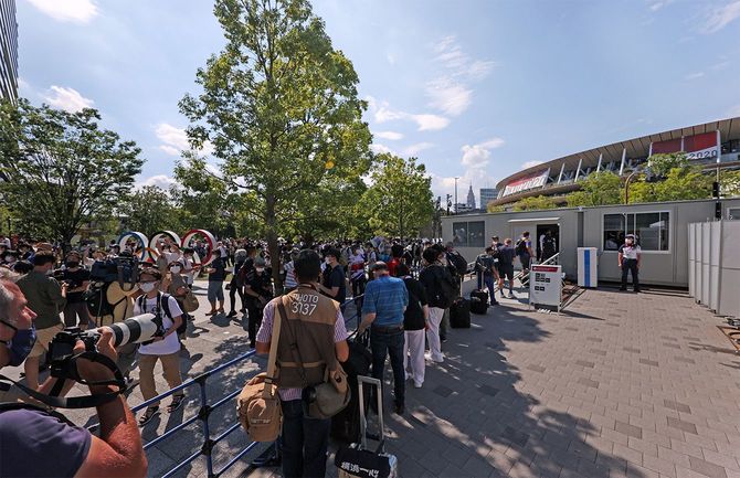 新型コロナウイルス感染拡大防止のため無観客で行われた東京五輪の開会式当日。会場の国立競技場周辺では五輪モニュメント（左奥）の前で撮影する多くの人たちの姿が見られた＝2021年7月23日、東京都新宿区