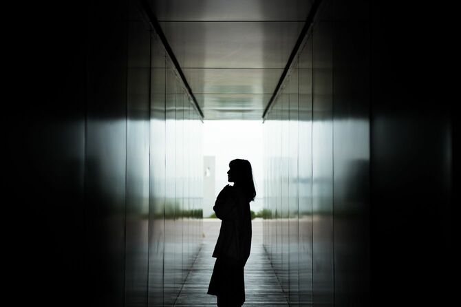 暗い廊下に立つ女性のシルエット