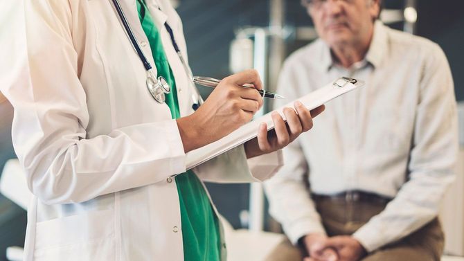 高齢の男性に問診をする医師