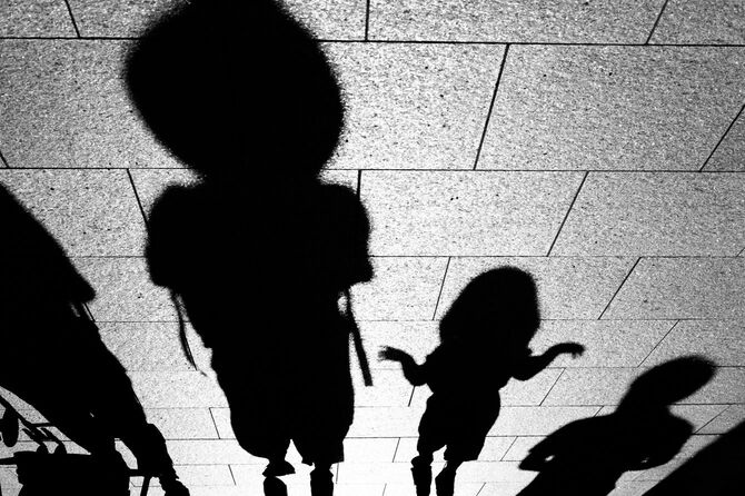 道に落ちた影がモンスターのように見える家族