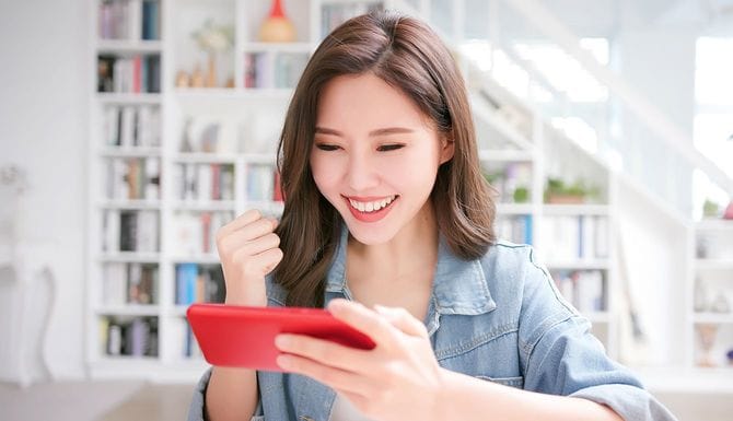 スマートフォンを見て笑顔の女性