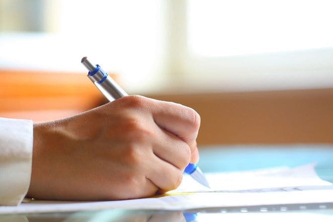 紙に書く人の手元