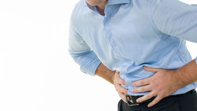 腹に痛みを感じる男性
