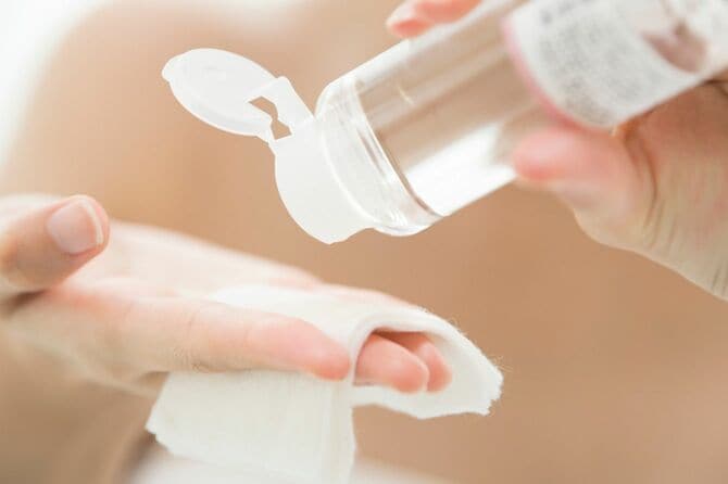 手にしたコットンに化粧水をたらす