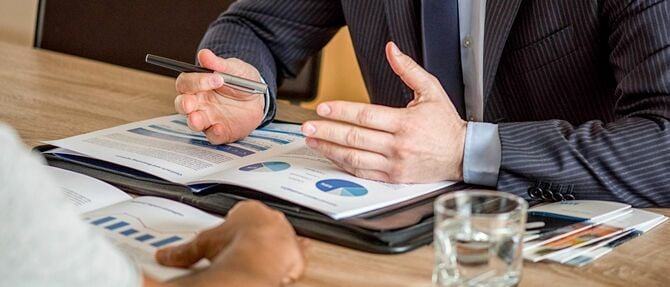 顧客にドキュメントを提示するビジネスマン