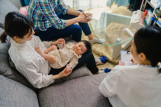 医師が赤ちゃんの患者の自宅を訪れ病状をチェック