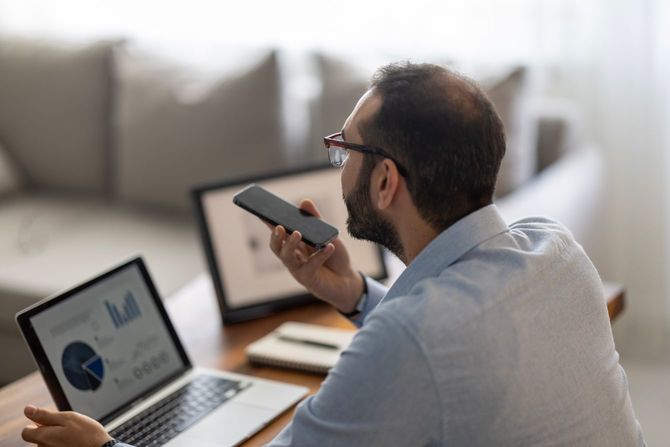 スマホで音声入力中の男性