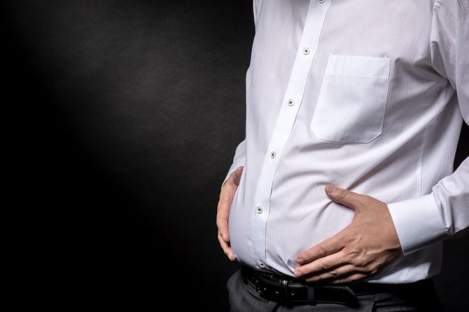 太った腹を気にする男性