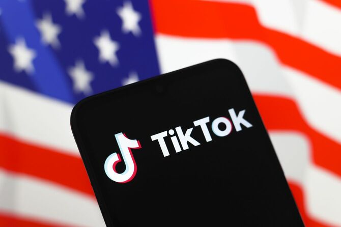 2024年11月18日、スマートフォンの画面にソーシャル・ネットワーク「TikTok」のロゴが表示。背景には星条旗