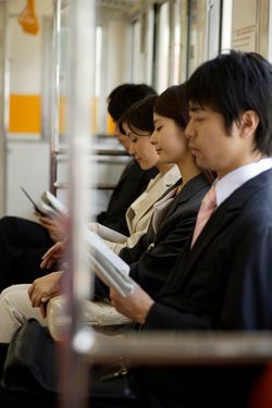電車の席に座るビジネスパーソンたち