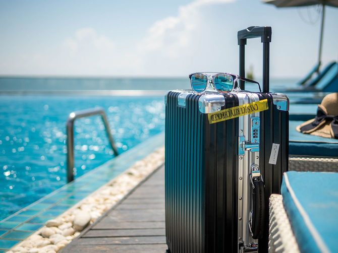 プールに旅行バッグとサングラス