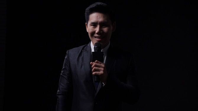 マイクを使って話す男性