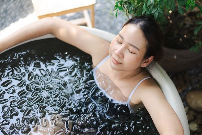 氷風呂でリラックスする若い女