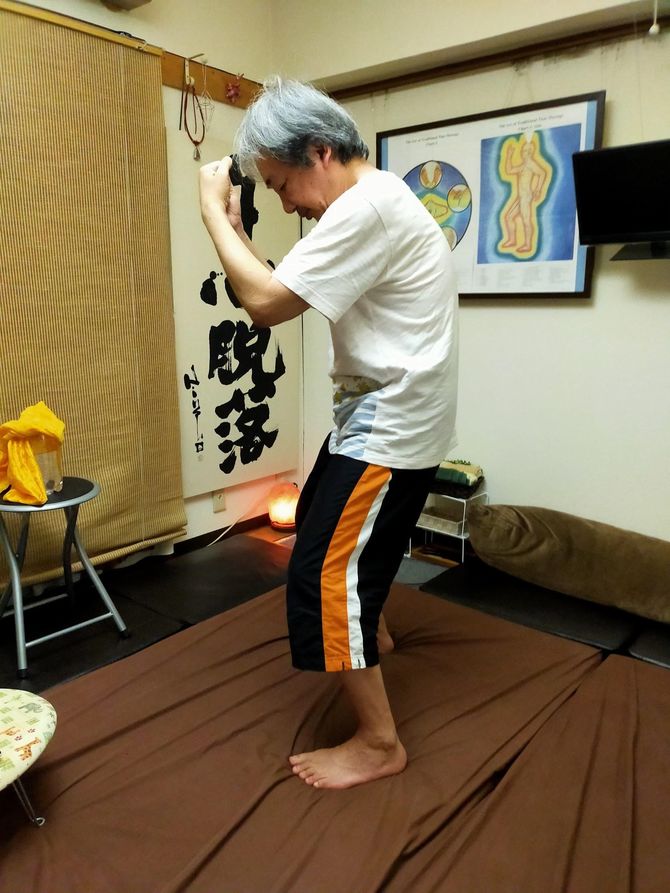 両腕を閉じ背中を丸めて息を吐く