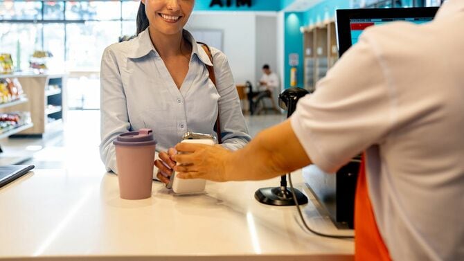 カフェでテイクアウトドリンクを購入する女性