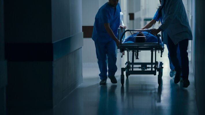 ストレッチャーで患者を手術室へ連れていく医療従事者