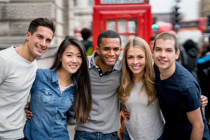 カメラを見ているロンドンの観光客の幸せな多民族グループ