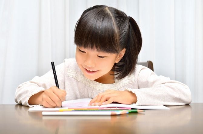 笑顔でドリルを解く女の子