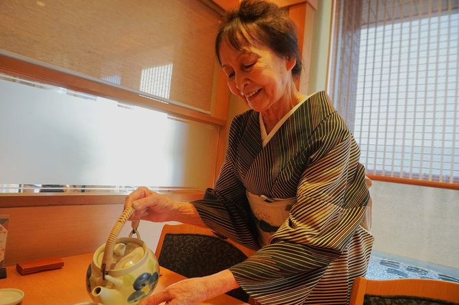 お客さんに笑顔で話しかけながら働く本田さん