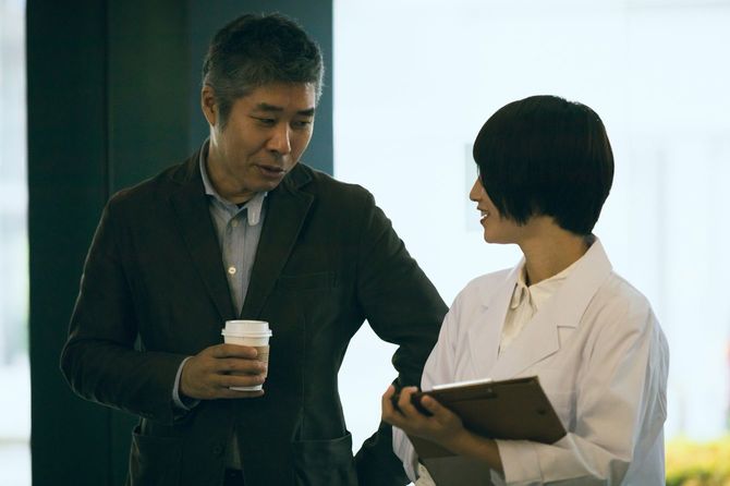 オフィスで話す若い女性と中年の男性