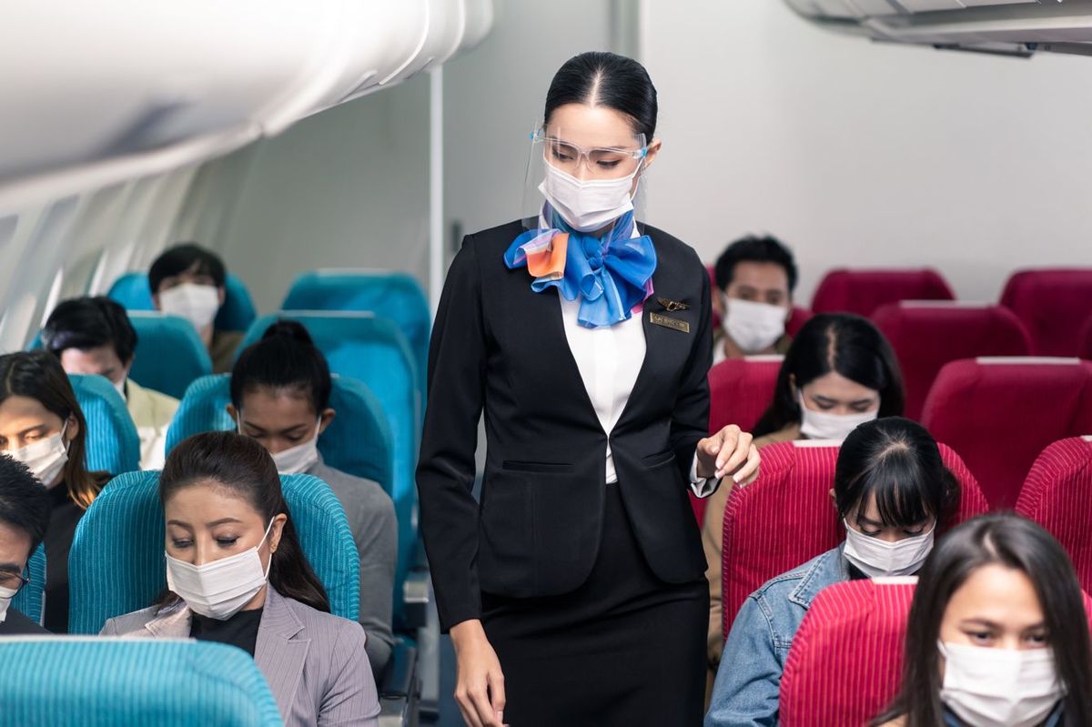 飛行機内でマスクを着用する人々