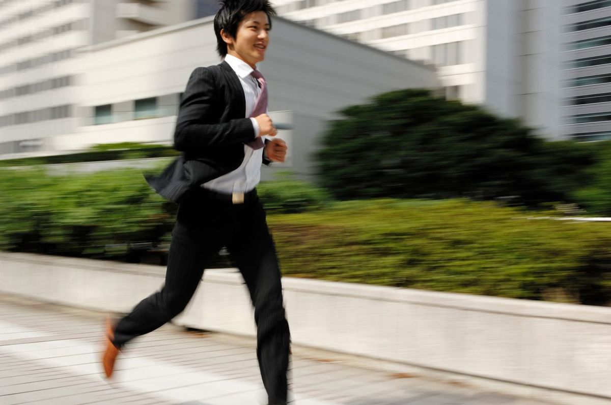 走っているスーツの男性