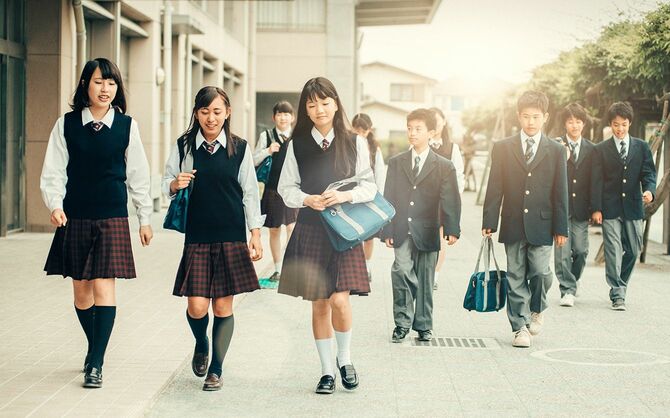 制服を着た日本の10代の生徒が学校に戻る