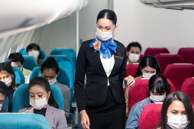 飛行機内でマスクを着用する人々