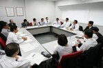 約20名の部員と部長が会議室に集まった。全員着席のまま、部長の話に耳を傾けている。