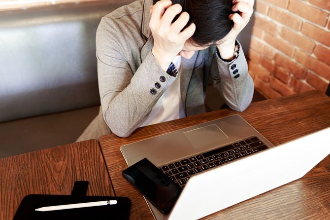 ストレスを感じながらパソコンに向かう男性