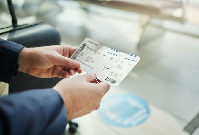 飛行機のチケットを手に
