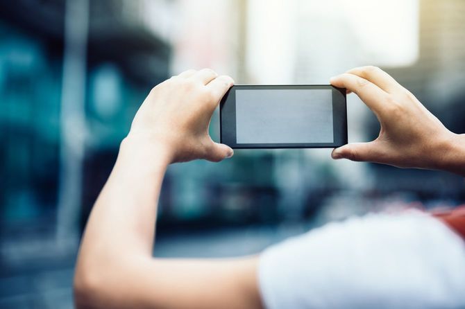 スマートフォンで何かを撮影している人