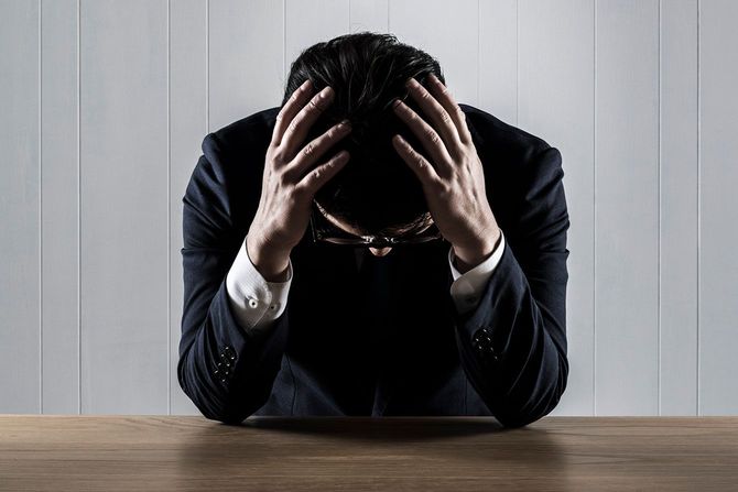 頭を抱えているビジネスマン