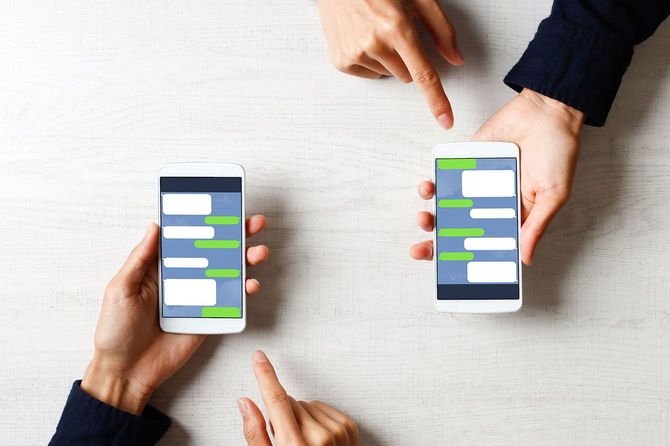 スマホに表示されたメッセージを見せ合う二人の手元