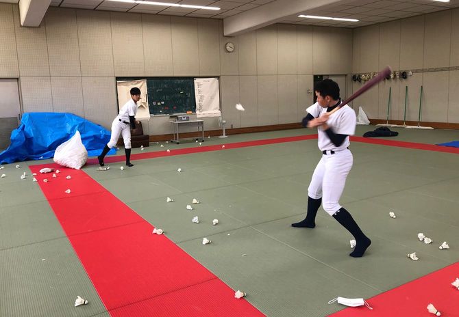 柔道場で打撃練習の一環としてバドミントンのシャトル打ちを行う野球部員