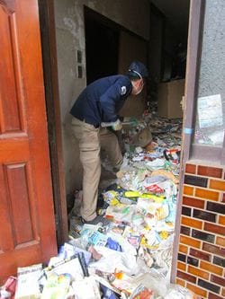 玄関にゴミがうずたかく積まれているので、まずはそれをかきだす。（撮影＝笹井恵里子）