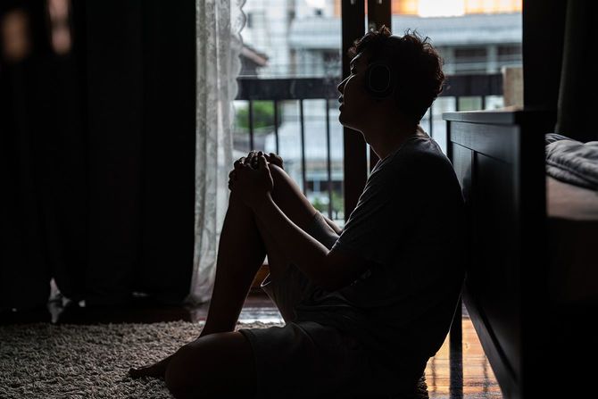 寝室に座っている悲しい男