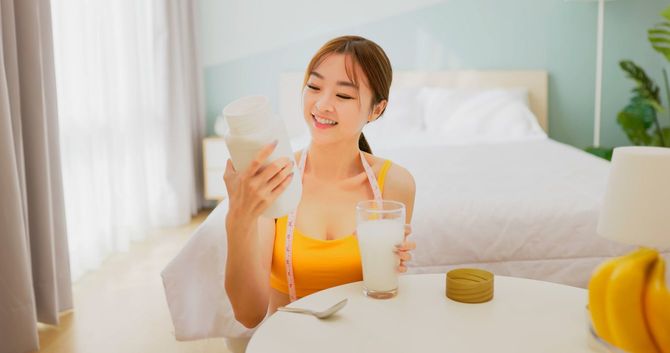 ダイエットのための巨大なシェーカーで作った飲料を手にしている女性
