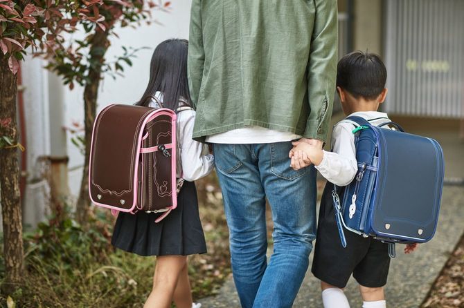 幼い子供を学校に連れて行く父親