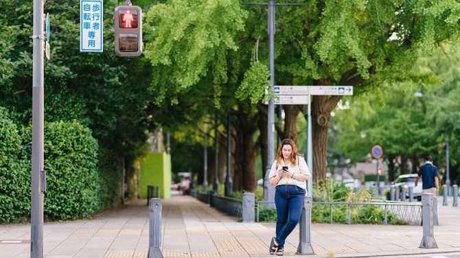 街中でスマホを使用するゴキゲンな女性