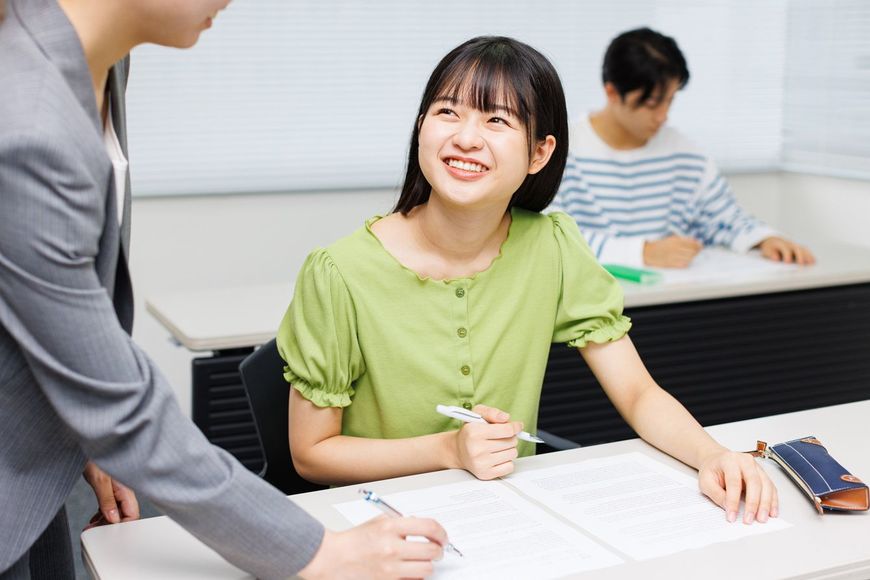 笑顔で先生の話を聞く女子生徒