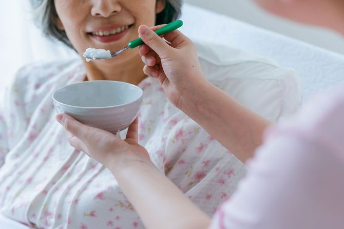 高齢者に食事の介助をする人