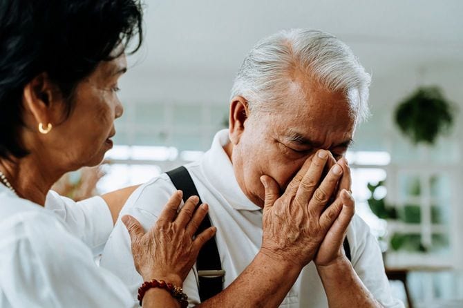 悲しむ老いた夫を慰める老いた妻
