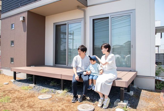 ウッドデッキに座る家族