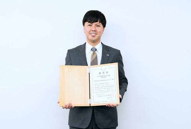 「HTT取組推進宣言企業　優良取組」の表彰状を手にほほ笑む斉京氏。