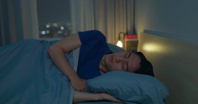ベッドで眠る男