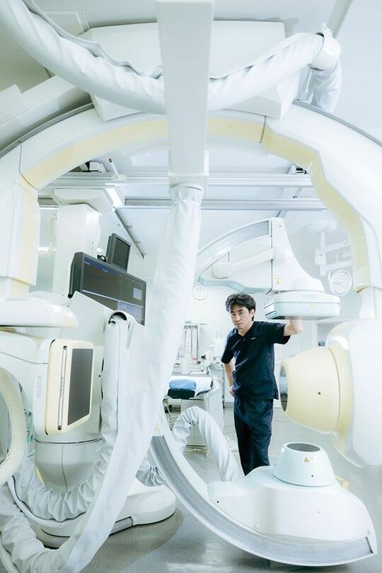血管造影装置と千船病院脳神経外科部長の榊原史啓さん。