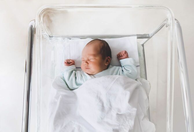 病院のベッドで寝ている新生児