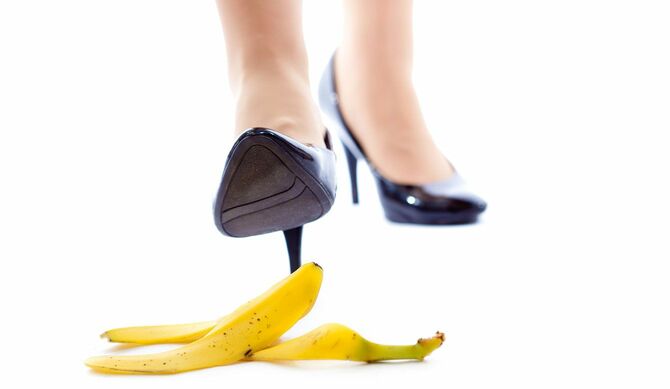 バナナの皮を踏みそうになっているハイヒールの女性の足元