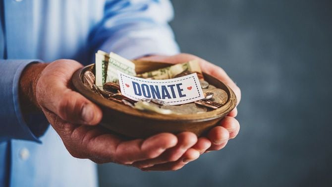 募金箱を持つ男性の手